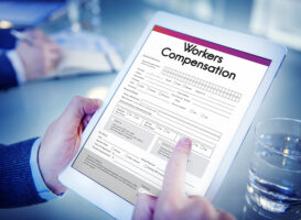 person holding a tablet with a workers compensation form pulled up