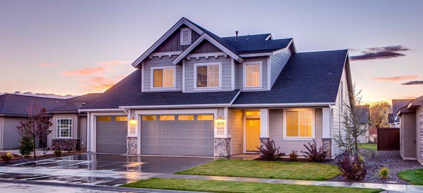 blue grey house lit up from the inside in the late evening, tips for new homeowners, spring home improvement tips
